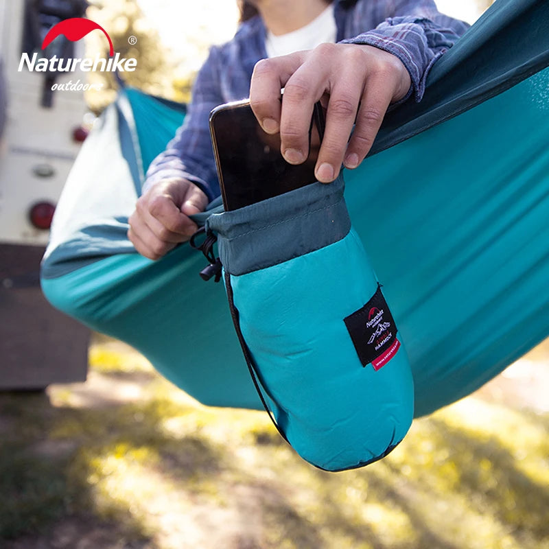 Nomad x Naturehike ultralight portable outdoor swing hammock hanging between trees, ideal for camping and outdoor relaxation.